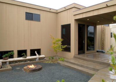 Modern home exterior with a fire pit in the courtyard.