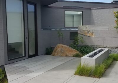 Modern house with a concrete walkway and minimalist landscaping.