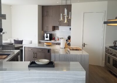 Modern kitchen with a marble island and stainless steel appliances.