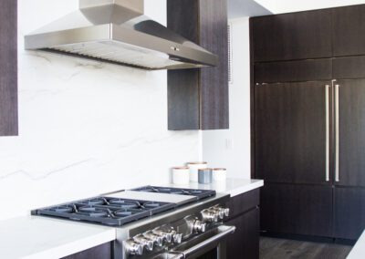 Modern kitchen with stainless steel appliances and dark cabinetry.