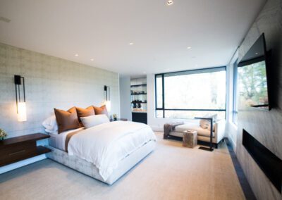 Modern bedroom with a king-size bed, minimalist decor, and a fireplace.