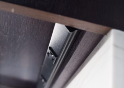Close-up of a cabinet hinge showcasing its installation and alignment with the cabinet.